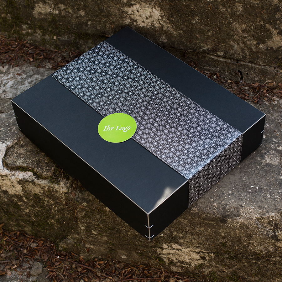 schwarze Box mit Banderole und Logoaufkleber